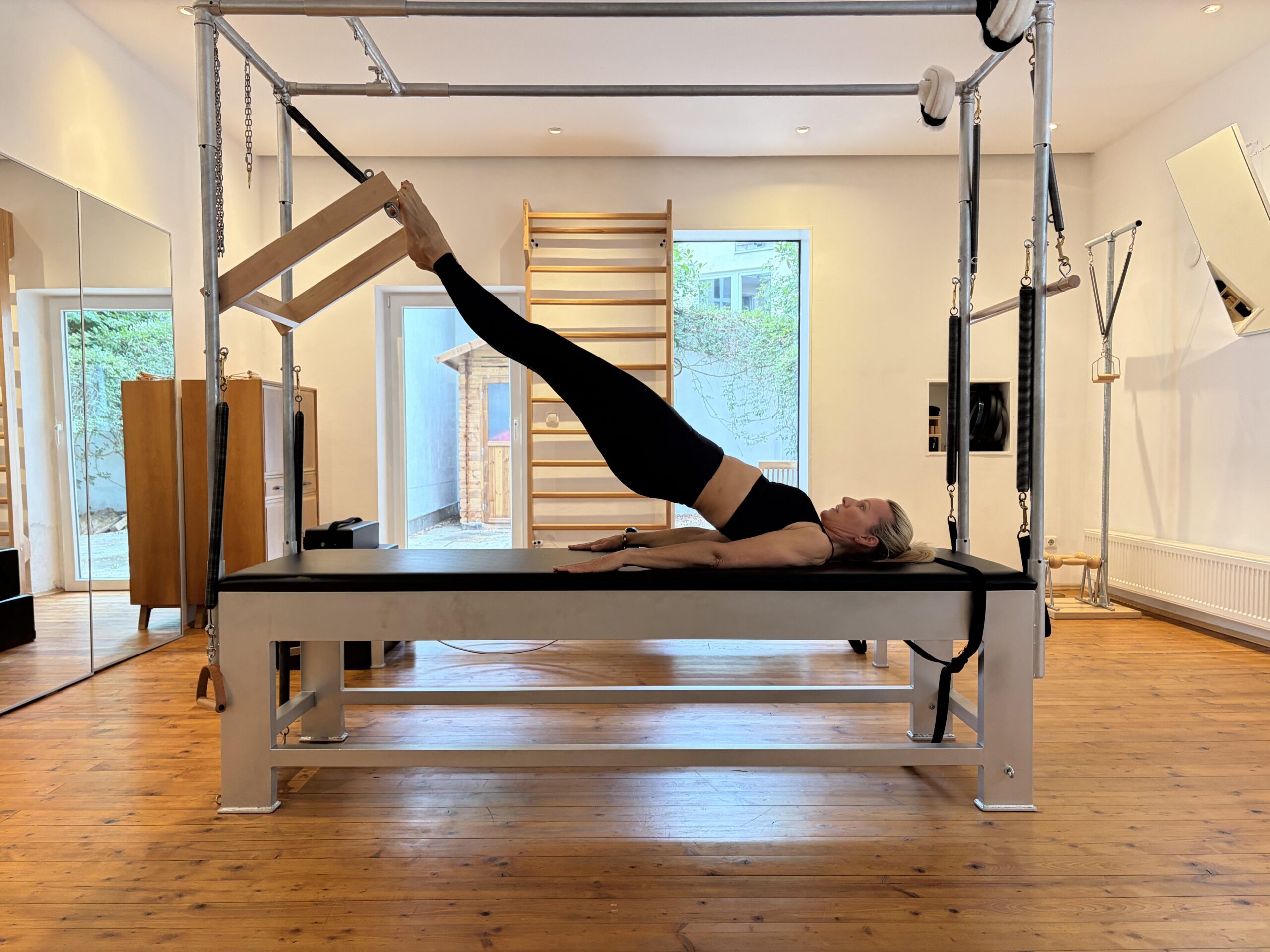 Klassische Pilates-Übung am Cadillac im hellen Studio von Uta Weber.